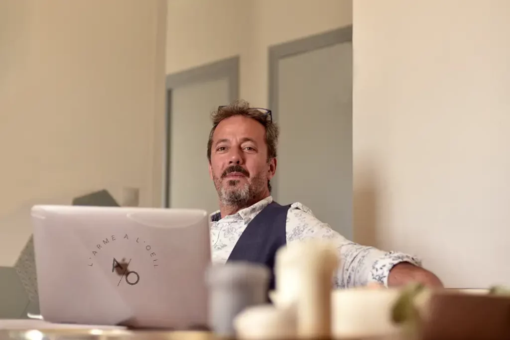 Portrait en lumière naturelle d'un homme à son bureau, regard déterminé